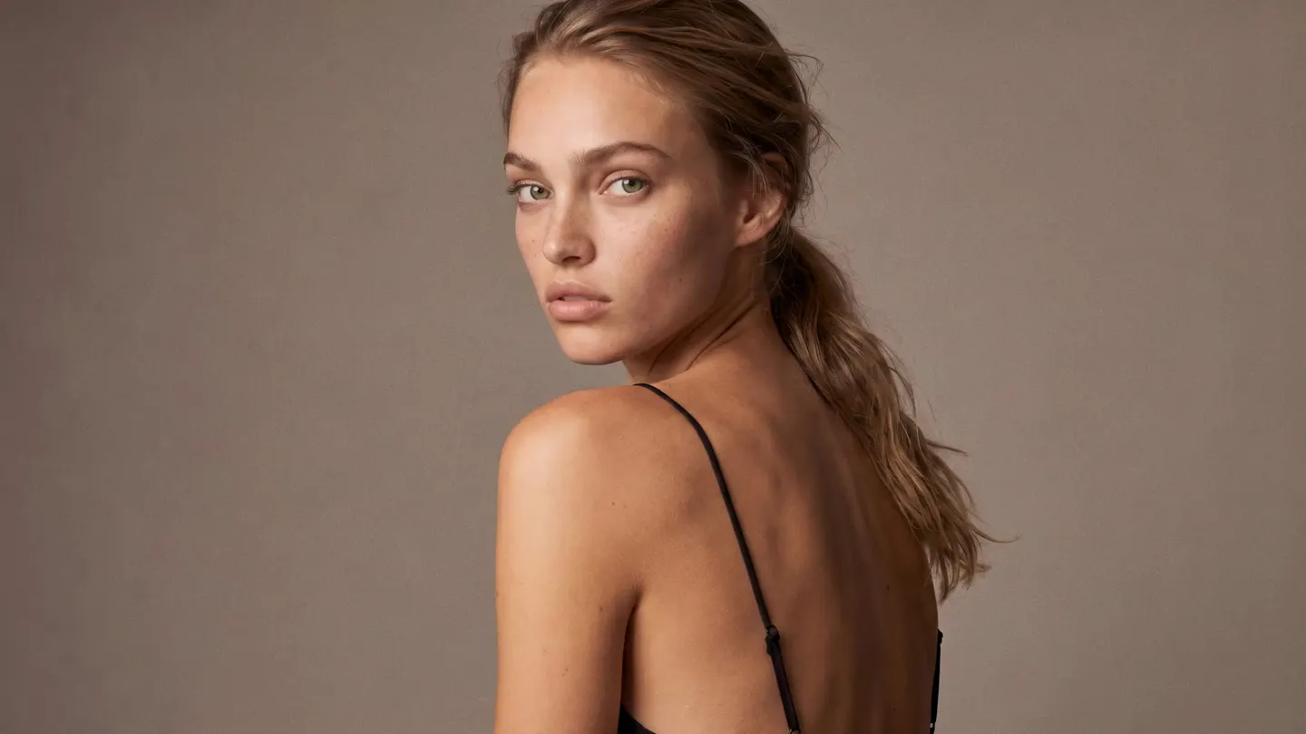 Model looking over her shoulder, bare throat — scroll to watch liquid gold form a panther necklace